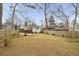 Large, grassy backyard with a wooden fence, mature trees, and a patio area perfect for outdoor entertaining at 1613 Westwood Sw Ave, Atlanta, GA 30310