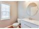 Modern bathroom with white vanity, round mirror, and a window for natural light at 215 Aldridge Pl # 9, Smyrna, GA 30082