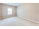 An empty bedroom with neutral walls, plush carpeting, and a window with bright, natural light at 215 Aldridge Pl # 9, Smyrna, GA 30082