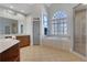 Bright bathroom with a soaking tub, tiled floors, a glass enclosed shower, and a picture window at 3493 Maryhill Nw Ln, Kennesaw, GA 30152