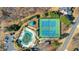 A pristine community pool and tennis courts are shown in an aerial view, set amongst trees at 3493 Maryhill Nw Ln, Kennesaw, GA 30152