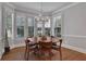 Sunlit dining room with a round wooden table and plantation shutters at 3493 Maryhill Nw Ln, Kennesaw, GA 30152