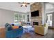 Comfortable living room with stone fireplace, ceiling fan, and natural light at 3493 Maryhill Nw Ln, Kennesaw, GA 30152