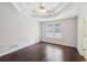 Bright bedroom with dark hardwood floors, white walls, a ceiling fan and a tray ceiling at 85 Windward Dr, Covington, GA 30016