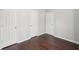 Bedroom with three white doors and dark flooring at 85 Windward Dr, Covington, GA 30016