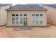 The rear of the home showcases a series of large windows and a door leading to a patio with a lawn at 2479 Brynfield Cv, Suwanee, GA 30024