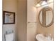 Powder room features a white sink, decorative mirror, and framed wall art at 2479 Brynfield Cv, Suwanee, GA 30024