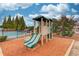 Community playground area with double slides and a nearby pool on a sunny day at 2479 Brynfield Cv, Suwanee, GA 30024