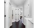 Hallway with dark hardwood floors and white trim with access to several rooms through white doors at 503 Stanford Pl, Woodstock, GA 30188