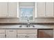 Bright kitchen sink with stainless steel appliances and a granite countertop under a window at 5515 Punkintown Rd, Douglasville, GA 30135