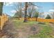 Large backyard with a wooden fence, play structure and mature trees at 960 Sugar Meadow Dr, Sugar Hill, GA 30518