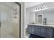 Bathroom featuring granite countertops, double vanity, framed mirror, walk-in shower, and tile floors at 960 Sugar Meadow Dr, Sugar Hill, GA 30518