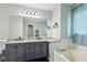 Bathroom featuring granite countertops, double vanity, framed mirror, and soaking tub at 960 Sugar Meadow Dr, Sugar Hill, GA 30518