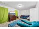 Cozy bedroom featuring a comfortable blue futon, entertainment center and a bright overhead light at 960 Sugar Meadow Dr, Sugar Hill, GA 30518