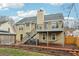 Exterior view of two-story home with back deck, black roof, and a finished backyard at 960 Sugar Meadow Dr, Sugar Hill, GA 30518