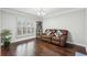 Comfortable living room featuring hardwood floors, a leather sofa, and natural light from the beautiful window at 960 Sugar Meadow Dr, Sugar Hill, GA 30518