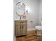 Powder room features wood flooring and a vanity with a black faucet and oval mirror at 2453 Paul Nw Ave, Atlanta, GA 30318