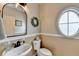 Charming half bath with a pedestal sink, oval window, and neutral wall color at 5030 New Chapel Hill Way, Cumming, GA 30041