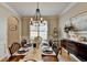 A dining room with wainscoting, a wooden table with 6 chairs, a chandelier, and hardwood floors at 5030 New Chapel Hill Way, Cumming, GA 30041