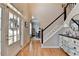 Light-filled foyer with staircase, wood flooring, decorative cabinet, and an arched entry to the dining room at 5030 New Chapel Hill Way, Cumming, GA 30041