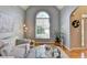 Bright living room featuring a large arched window, hardwood floors, and modern furnishings at 5030 New Chapel Hill Way, Cumming, GA 30041