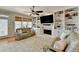 Cozy living room features a ceiling fan, built-in shelving, fireplace, and comfortable sofas at 5030 New Chapel Hill Way, Cumming, GA 30041