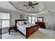 Primary bedroom with a tray ceiling, furniture set, and natural light at 5030 New Chapel Hill Way, Cumming, GA 30041