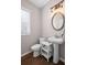 Charming half bathroom featuring modern pedestal sink, updated fixtures, and wood-look flooring at 5975 Vista Brook Dr, Suwanee, GA 30024