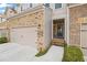 Townhome exterior featuring a brick facade, attached garage and welcoming front entrance at 5975 Vista Brook Dr, Suwanee, GA 30024