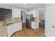 Kitchen boasts stainless steel refrigerator, granite counters, and wood flooring at 5975 Vista Brook Dr, Suwanee, GA 30024