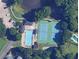 Aerial view of the community pool and tennis courts with lots of greenery and parked cars at 1061 Steeple Run, Lawrenceville, GA 30043