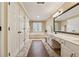Bright bathroom with double sinks, large mirror, soaking tub, multiple cabinets, and neutral tiling at 1061 Steeple Run, Lawrenceville, GA 30043