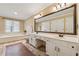 Bright bathroom with double sinks, large mirror, soaking tub, multiple cabinets, and neutral tiling at 1061 Steeple Run, Lawrenceville, GA 30043