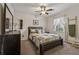 Cozy bedroom with a ceiling fan, neutral walls, a comfortable bed, and a window with sheer curtains at 1061 Steeple Run, Lawrenceville, GA 30043