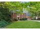 Traditional two-story brick home boasts a lush green lawn and attached two car garage at 1061 Steeple Run, Lawrenceville, GA 30043