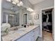 Bathroom with dual granite vanity, framed mirror, tile flooring and walk-in shower with glass enclosure at 1431 Torrington Dr, Auburn, GA 30011