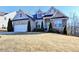 Charming home featuring a stone facade, well-manicured landscaping, and an attached two-car garage at 1431 Torrington Dr, Hoschton, GA 30011