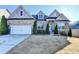 Charming home featuring a stone facade, well-manicured landscaping, and an attached two-car garage at 1431 Torrington Dr, Hoschton, GA 30011