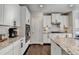 Well-lit kitchen boasts stainless steel appliances, granite countertops, and white cabinetry with modern, black hardware at 1431 Torrington Dr, Auburn, GA 30011