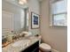 Modern powder room with granite countertop, stylish fixtures, and a decorative mirror at 1431 Torrington Dr, Auburn, GA 30011