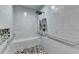 Bright accessible shower featuring tiled walls, pebble floor, built in bench, and safety hand rails at 1431 Torrington Dr, Auburn, GA 30011
