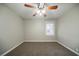 This bedroom features neutral walls, carpeted floors, a ceiling fan, and a window that lets in natural light at 1770 Lynn Ln, Decatur, GA 30032