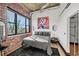 Spacious bedroom with exposed ductwork, brick wall, and natural light at 3235 Roswell Ne Rd # 710, Atlanta, GA 30305