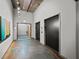 Hallway with two elevators on the right and neutral walls with an exit sign at the end of the hall at 3235 Roswell Ne Rd # 710, Atlanta, GA 30305