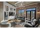 Living room features exposed brick, hardwood floors, a comfortable sofa, and bright windows with a neighborhood view at 3235 Roswell Ne Rd # 710, Atlanta, GA 30305