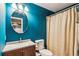 Bathroom with a vanity, sink, toilet, shower with curtain, round mirror and teal walls at 4646 Breakwater Trl, Marietta, GA 30066