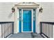 Close-up of a stylish blue front door with decorative accents, a modern door bell, and classic sconces at 4646 Breakwater Trl, Marietta, GA 30066