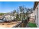 A view from the balcony that features beautiful trees, a quaint house, and an ample lawn on a sunny day at 10 Colony Ridge Dr, Alpharetta, GA 30022