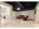 Finished basement providing flexible living space with a cozy seating area, tiled floors and exposed ceiling at 10 Colony Ridge Dr, Alpharetta, GA 30022