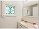 Elegant half-bathroom featuring a decorative window and well-lit mirror at 10 Colony Ridge Dr, Alpharetta, GA 30022